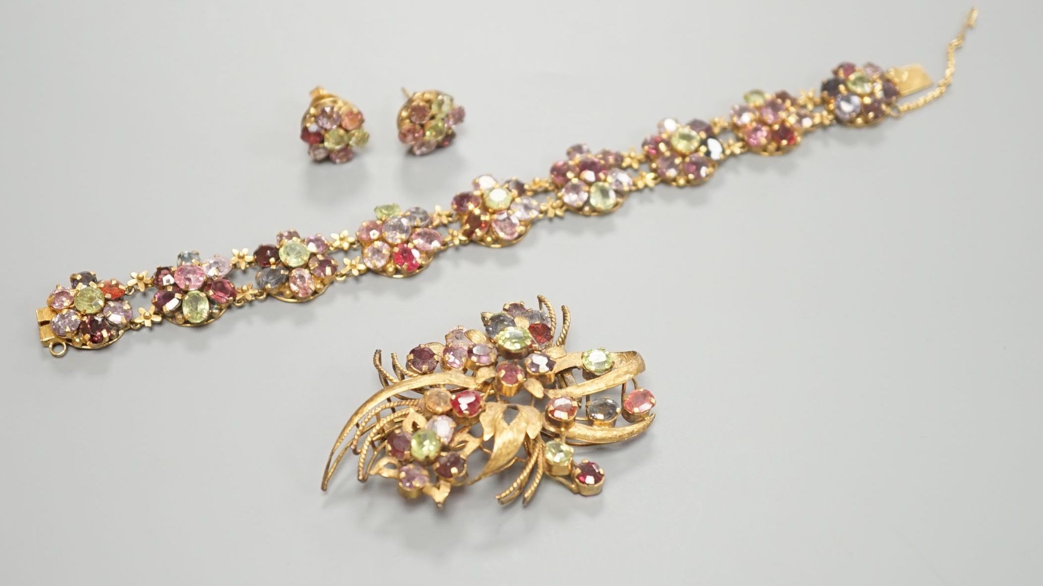 A gilt metal and coloured paste set bracelet and pair of earrings and a similar brooch, 6cm.